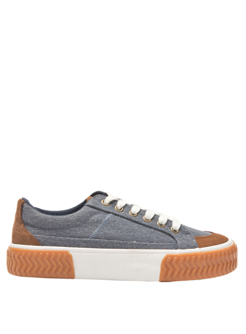Zapatilla azul casual de mujer con suela gruesa zigzag y detalles en textil y cuero de estilo urbano.