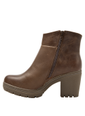 Elegante botín boho-chic de cuero marrón para mujer, con tacón grueso y ornamento trenzado bajo la hebilla lateral.