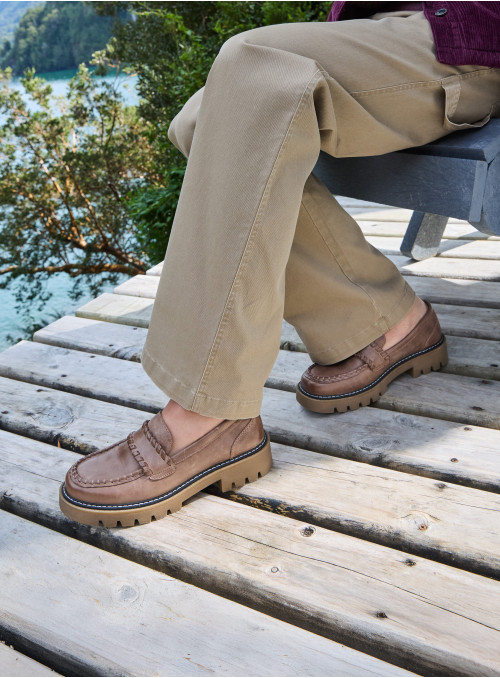 Mocasín casual de cuero taupe para mujer, detalle artesanal en costuras y lengüeta trenzada, ideal para uso diario.