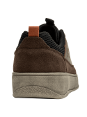 Elegante zapatilla de cuero café con ojales metálicos y suela gris clara.