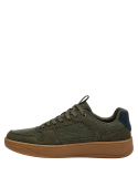 Calzado casual normcore en cuero verde con ojales metálicos y suela café.