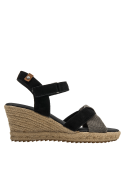 Sandalia de mujer con cuña de yute y tiras cruzadas, combinando cuero negro y texturas contrastantes.