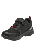Zapatilla infantil negra con malla transpirable y suela moteada blanca, perfecta para uso urbano y deportivo.