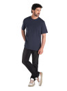 Jeans negro casual para hombre con cinco bolsillos, detalle de cierre y botón metálico.