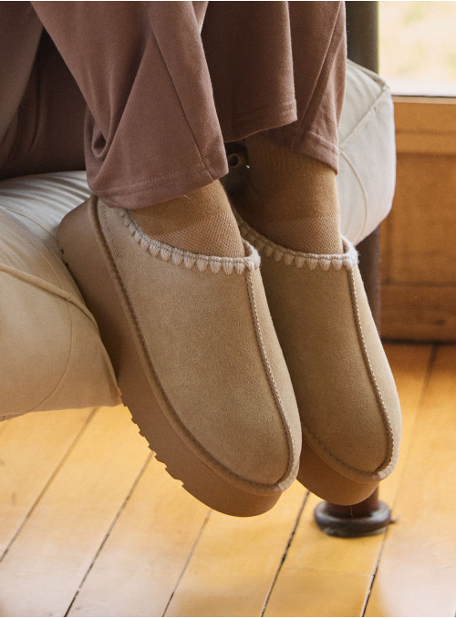 Pantuflas de 5.5 cm de altura en color beige, perfectas para un look relajado y acogedor.